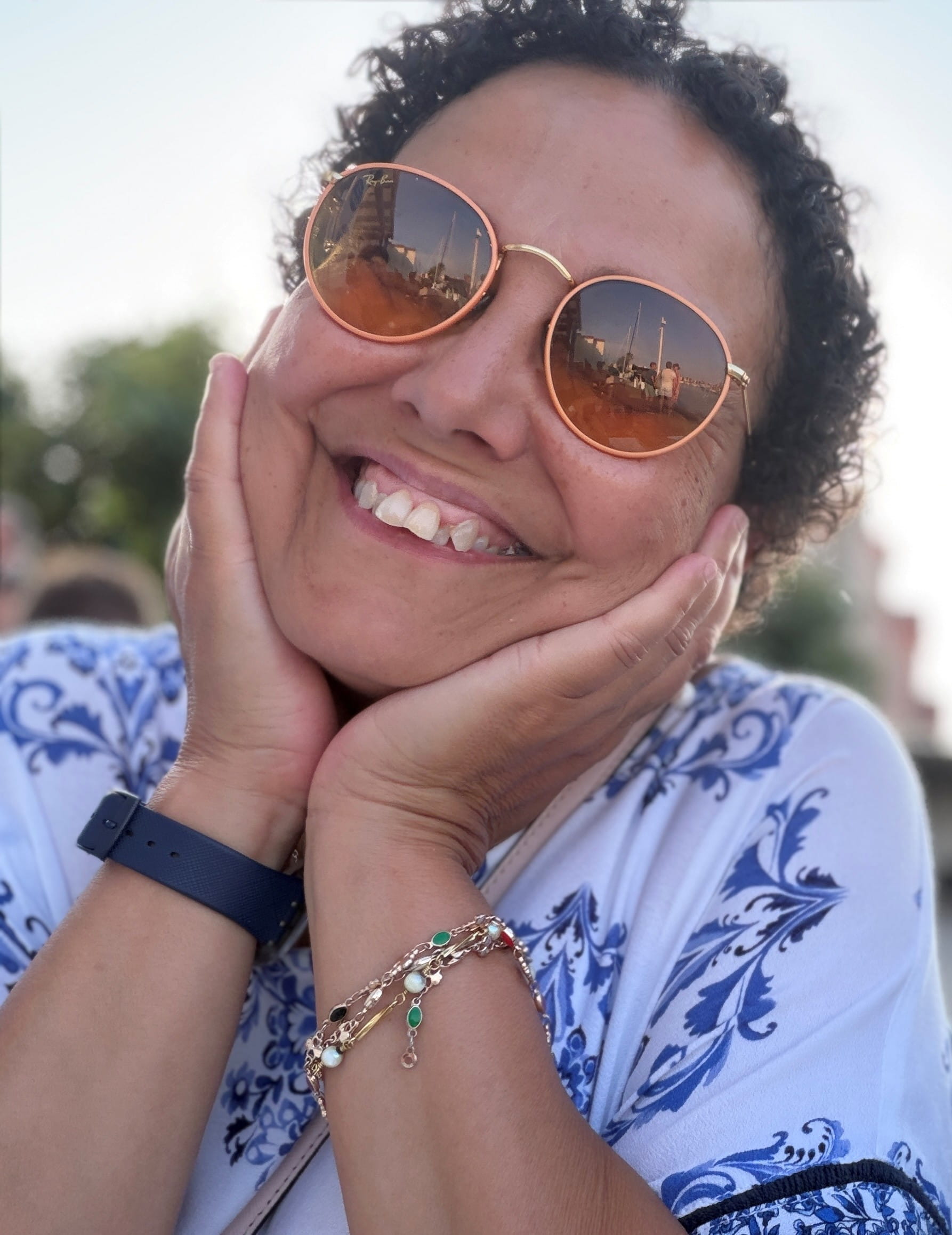 Assia Meddane, souriante, le visage appuyé dans ses mains.