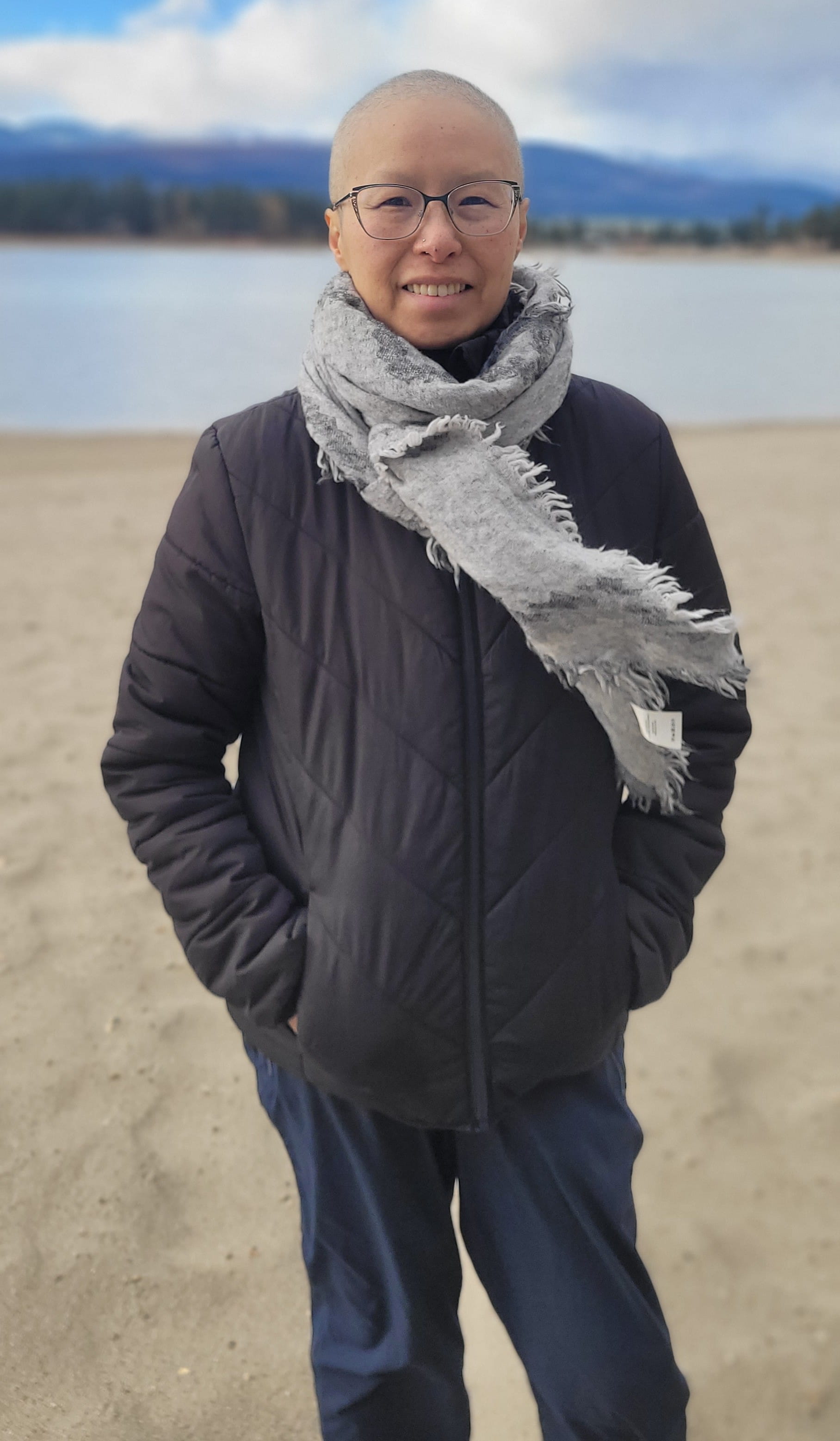 Rita Pak standing on a beach after losing her hair.