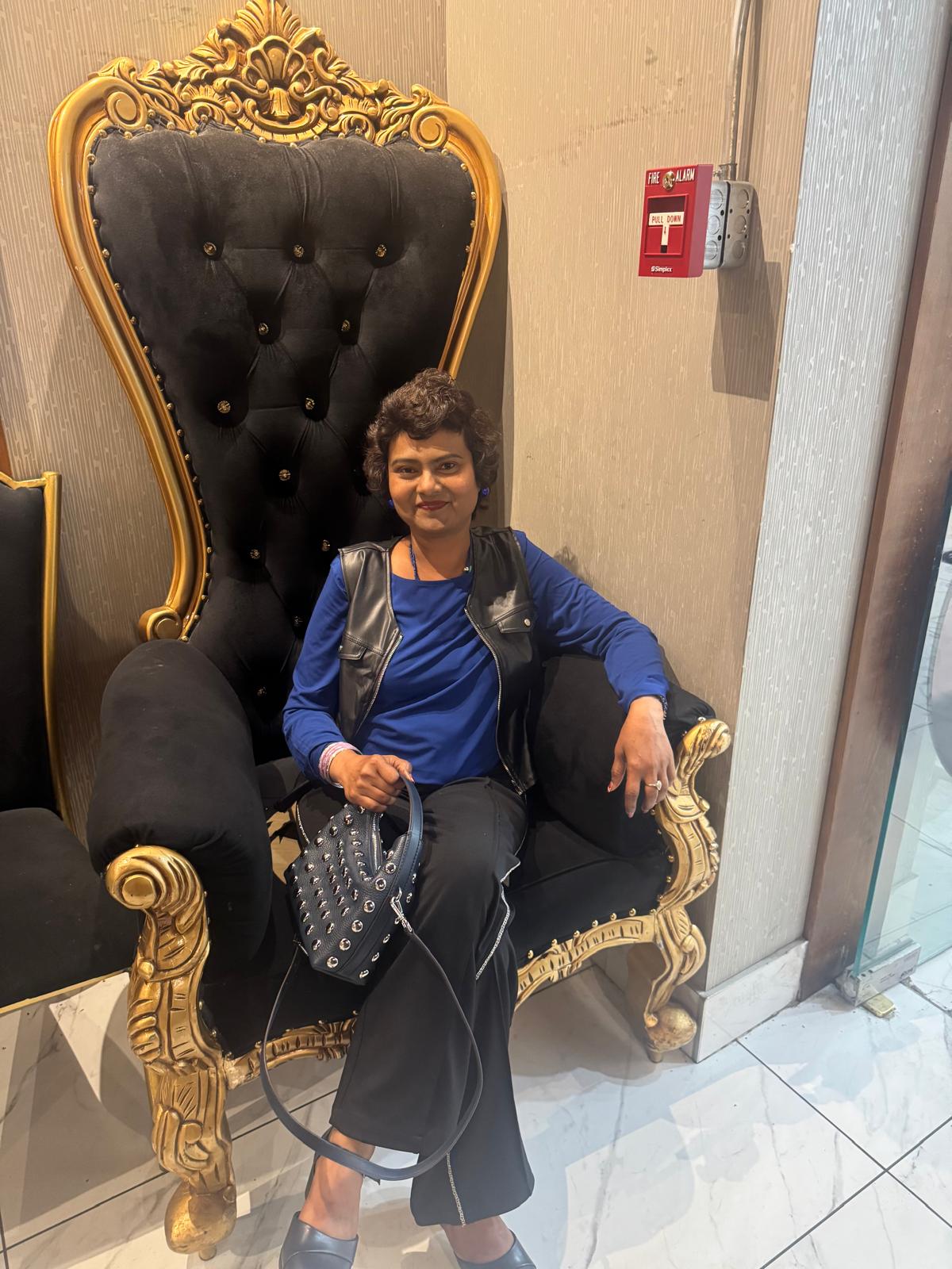 Yasmeen Akhtar sitting on a chair.