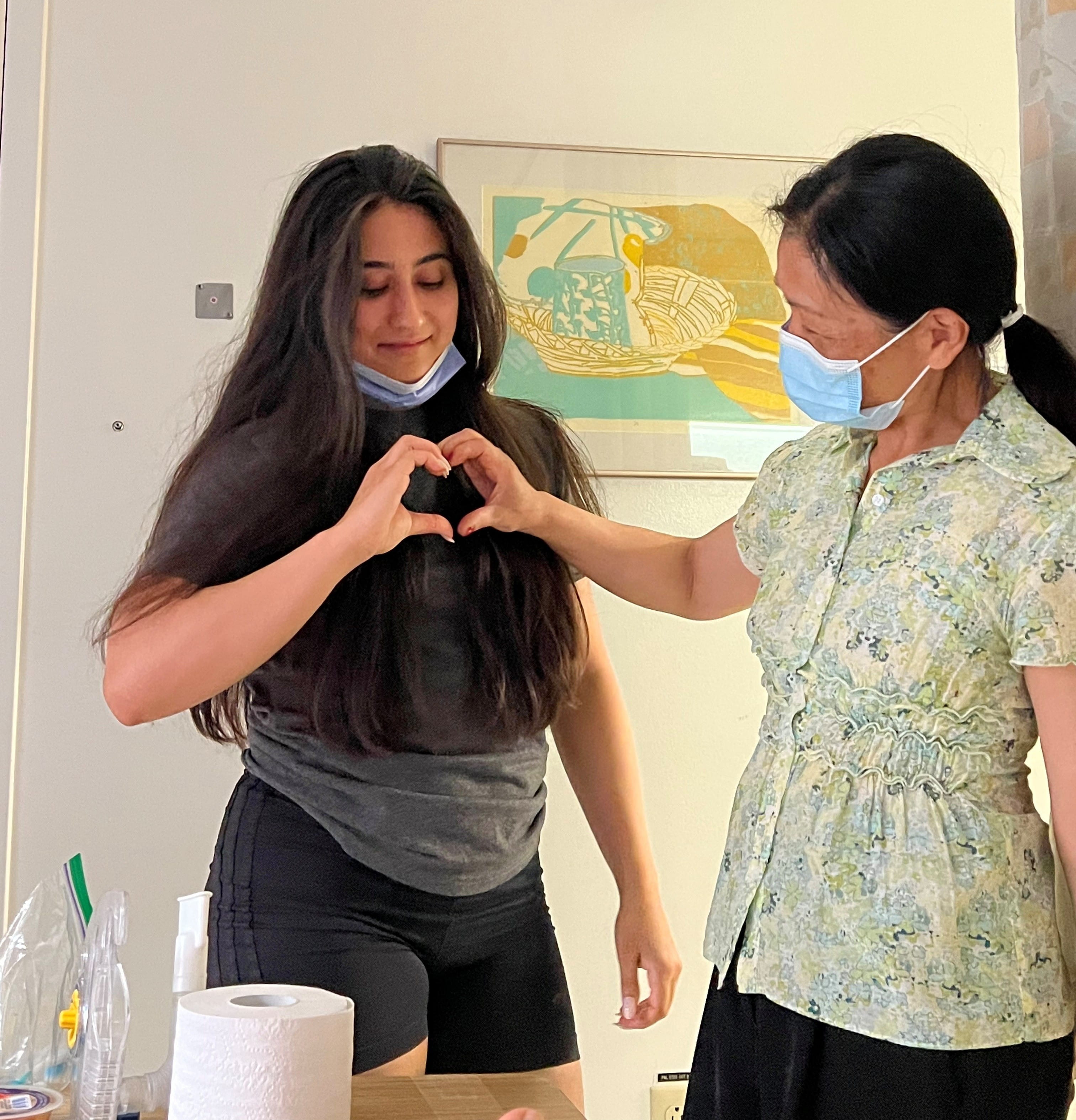 La sœur de Caitlin et sa mère se tiennent la main pour former un cœur.