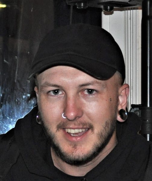 Nick looks at the camera and smiles.