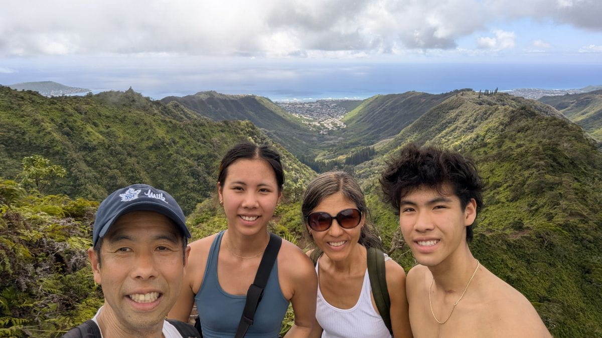 Winhan, his wife and their 2 children smile while on a hike together.