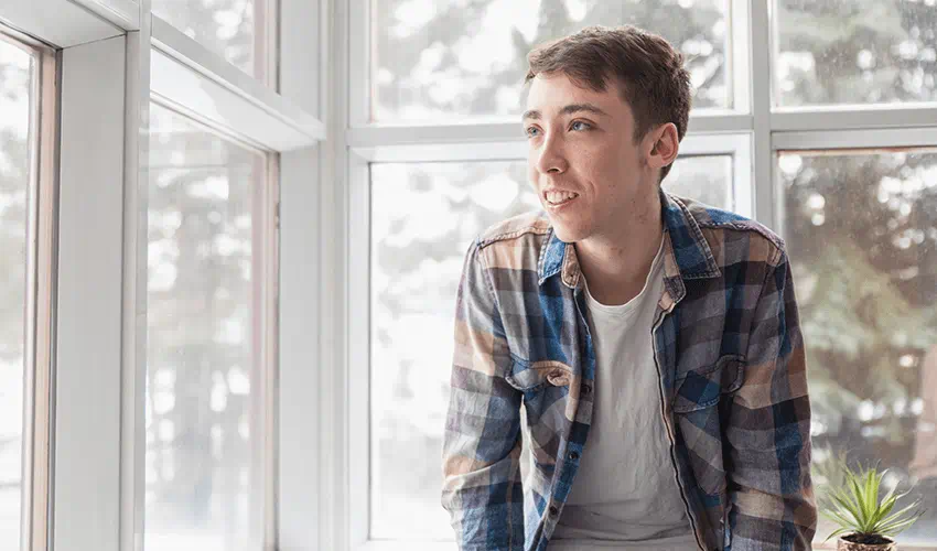 Vincent smiling in front of windows.