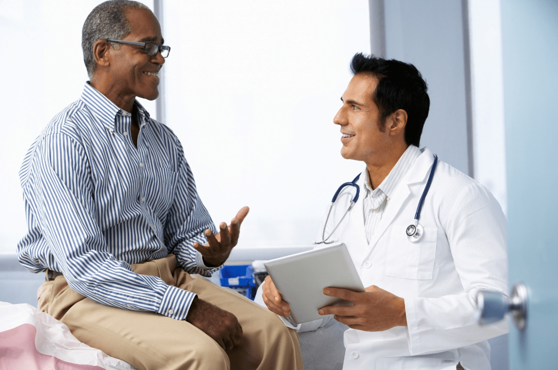 Healthcare professional speaking with a patient during a medical appointment.