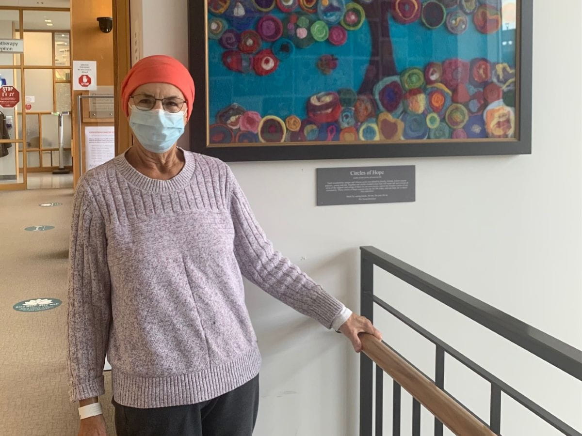 Bonnie se tient debout à l'hôpital, portant un masque et un foulard.
