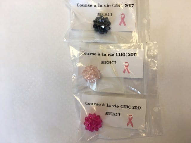 Breloques en forme de fleur dans de petits sacs de plastique, avec un mot disant « Course à la vie CIBC 2017. Merci. »