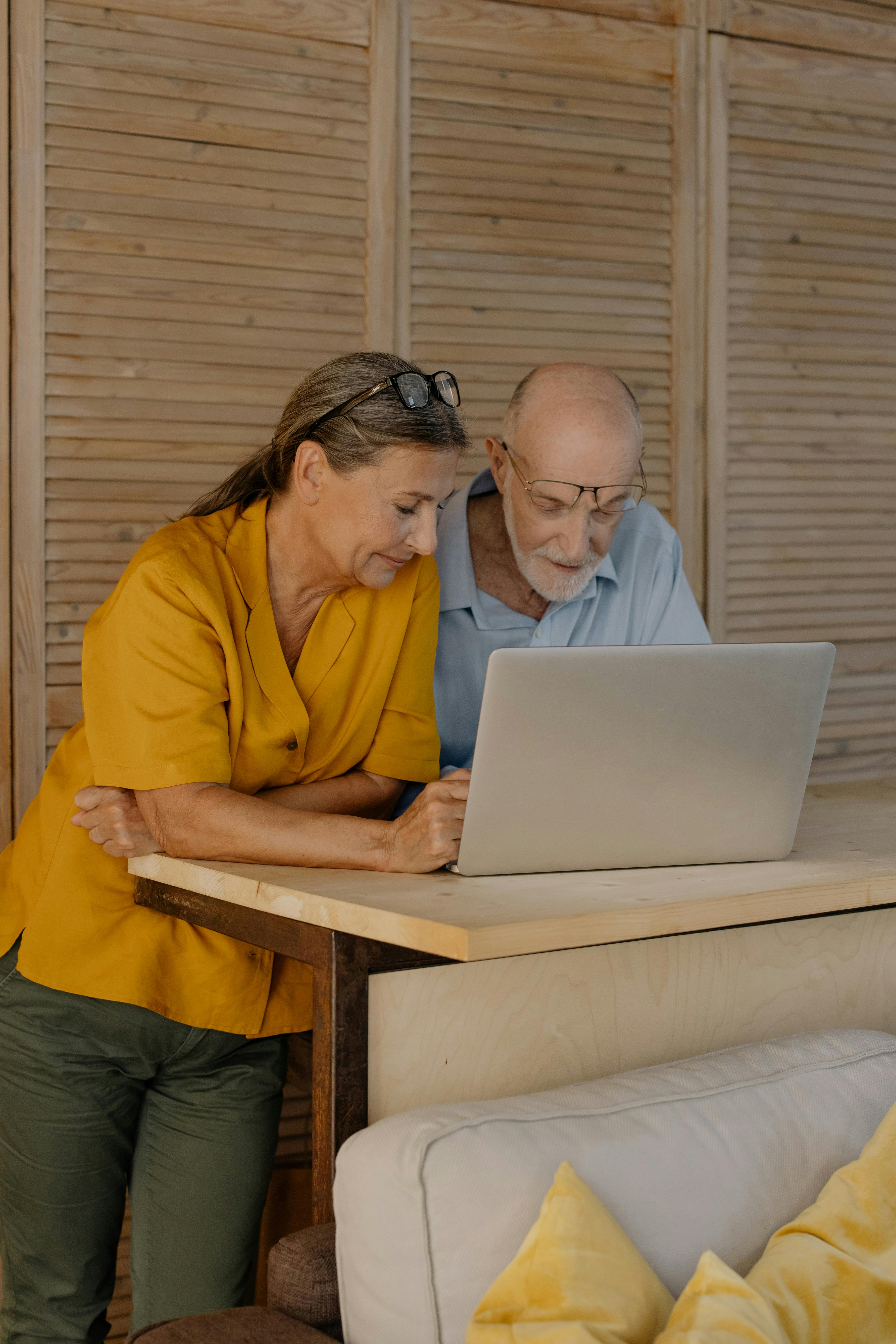 Two people leaning over a laptop.