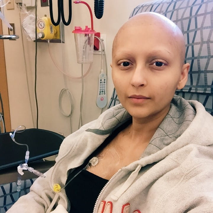 Avani assise à l’hôpital en train de recevoir un traitement de chimiothérapie.  