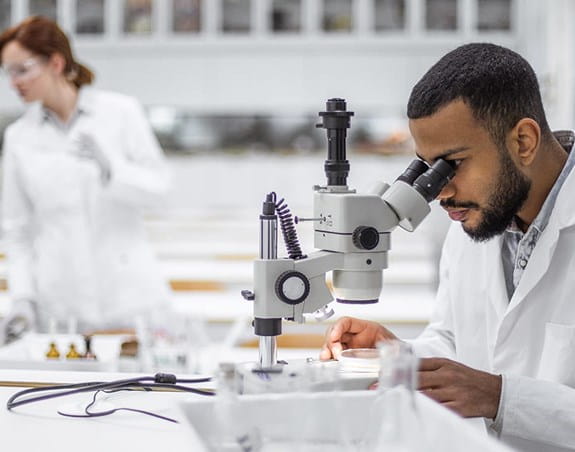 A researcher looking into a microscope in a laboratory