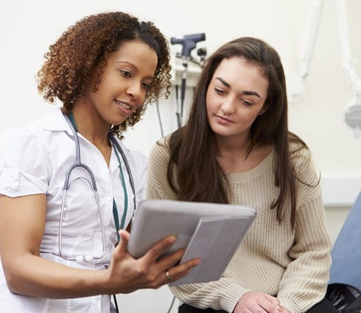 Patient and healthcare professional reviewing something on a tablet