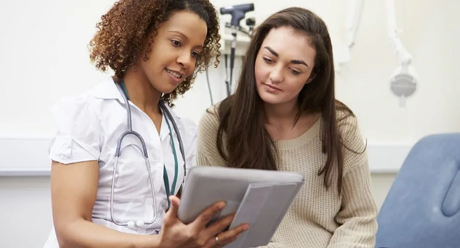 Patient and healthcare professional reviewing something on a tablet
