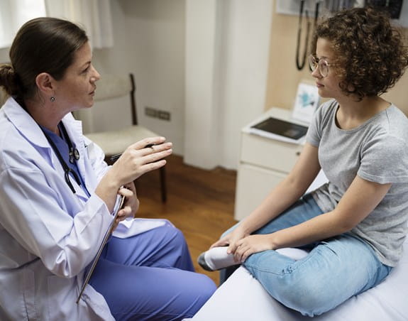 Physician talking to a patient in an exam room