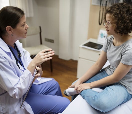 Physician talking to a patient in an exam room