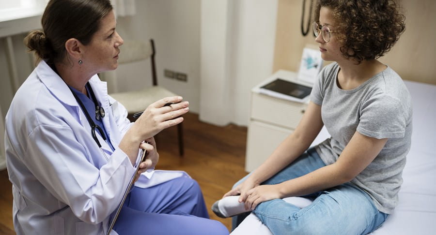 Physician talking to a patient in an exam room