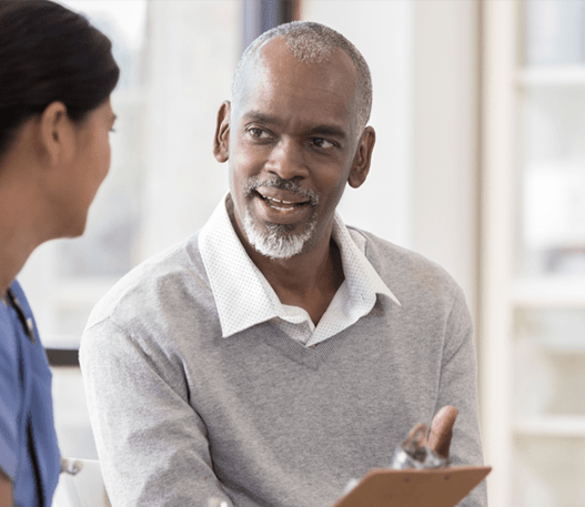 Two people at a medical office reviewing something on a clipboard