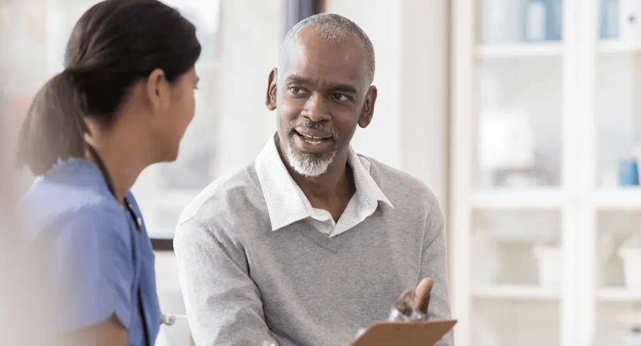Two people at a medical office reviewing something on a clipboard