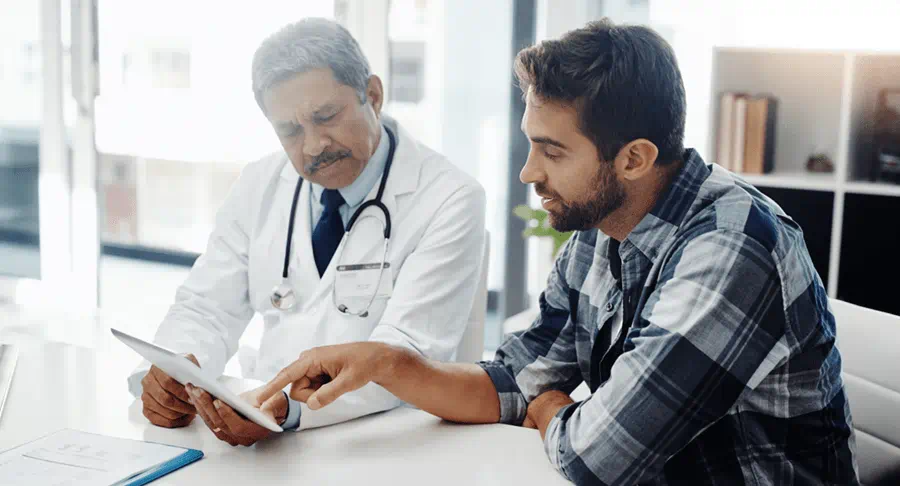 Patient reviewing a list of questions with their doctor