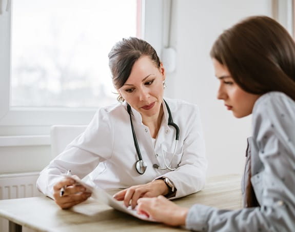 A doctor talking to a cancer patient in a hospital.