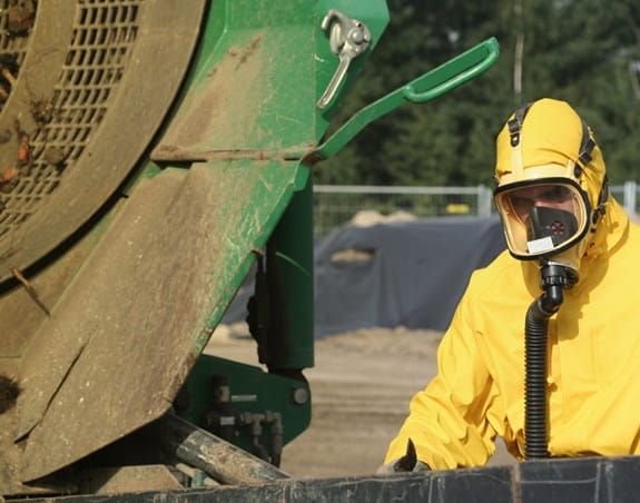 Worker in protective gear disposing of asbestos
