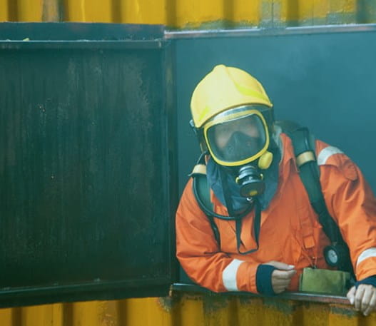 Pompier portant un équipement complet et un masque à oxygène dans un endroit enfumé