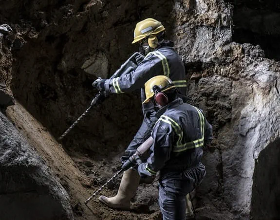 Workers drilling in a mine