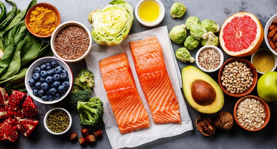 Assortiment d’ingrédients : grains, noix, légumes, fruits et saumon