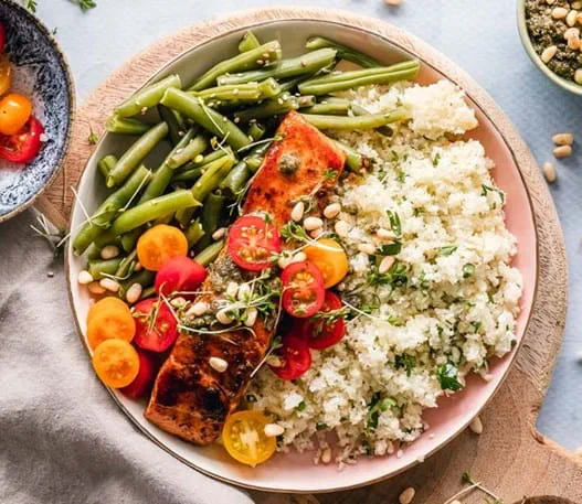 Dinner plate with salmon, vegetables and fruit, and grains