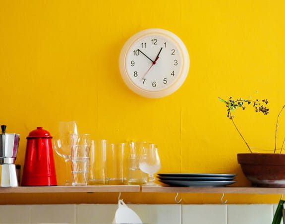 A clock hanging in a kitchen