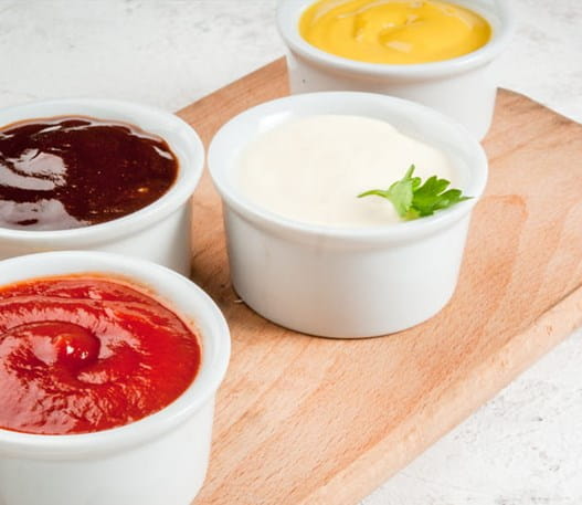 Petits bols de ketchup, de moutarde et d’autres condiments