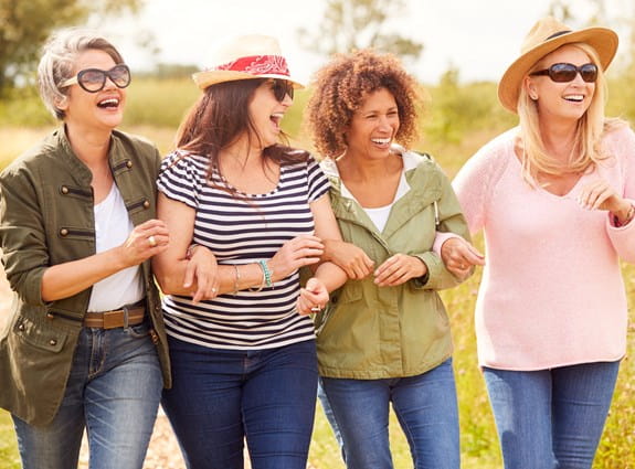 A group of women holding arms