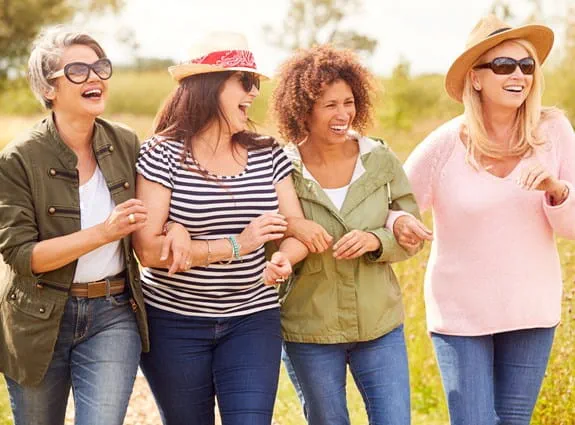 A group of women holding arms