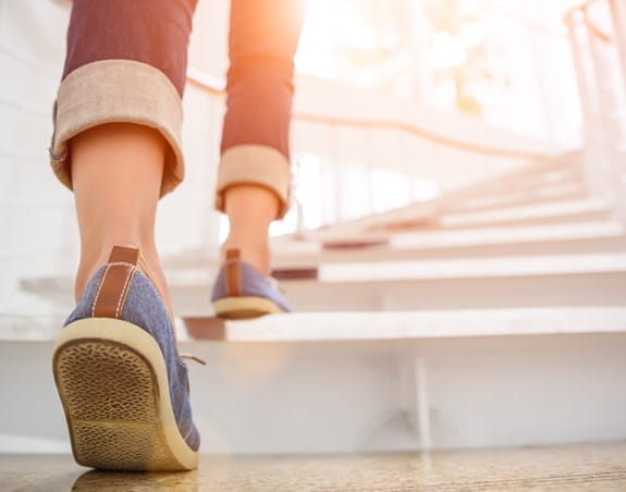 Person walking up a set of stairs outside