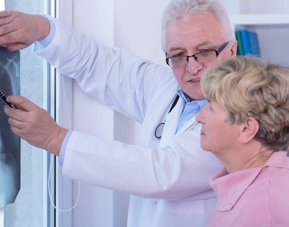 Un médecin examinant une radiographie pulmonaire en compagnie d’une patiente