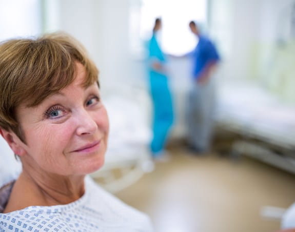 Patient in a hospital bed wearing a gown