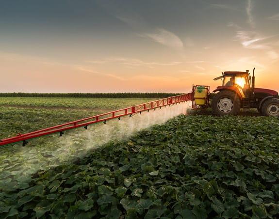 Tracteur pulvérisant des pesticides dans des champs