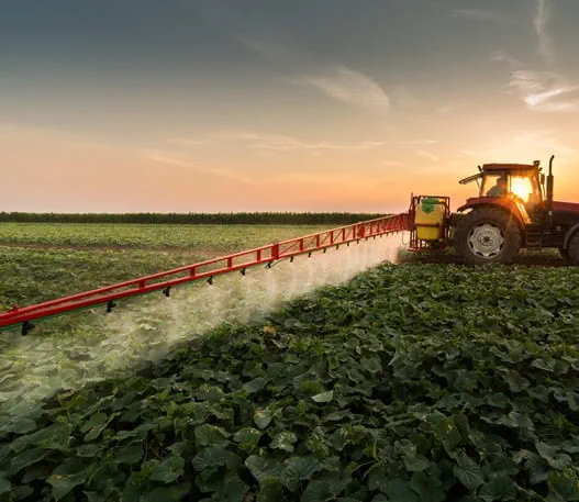 Tractor spraying crops with pesticides