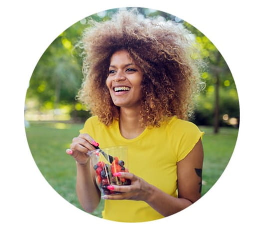 Person sitting outside on the grass eating berries