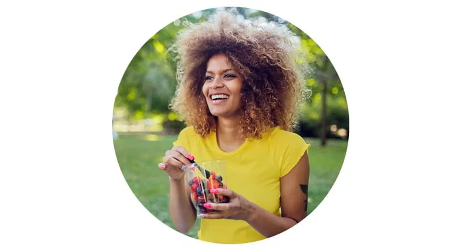 Person sitting outside on the grass eating berries