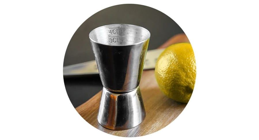 Un verre doseur à côté d’une lime