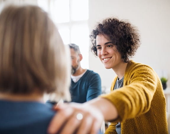 Une personne posant la main sur l’épaule d’une amie avec compassion