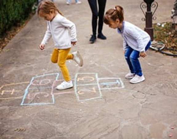Two children playing hopscotch