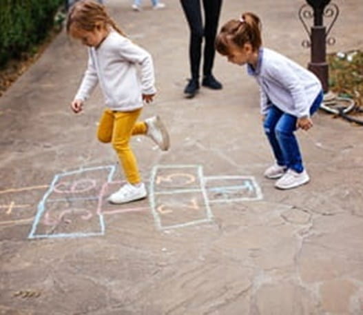 Two children playing hopscotch