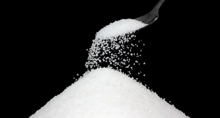 Sugar being poured from a teaspoon