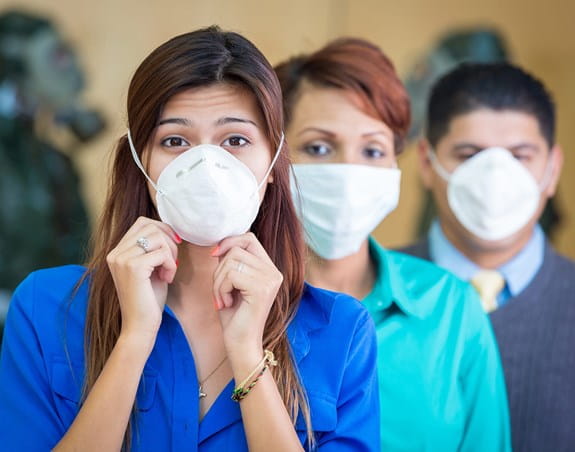 Three people wearing medical face masks