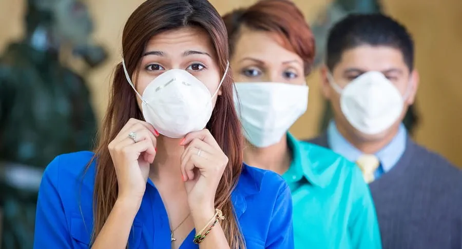 Three people wearing medical face masks