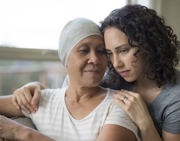 A cancer patient being embraced by another person