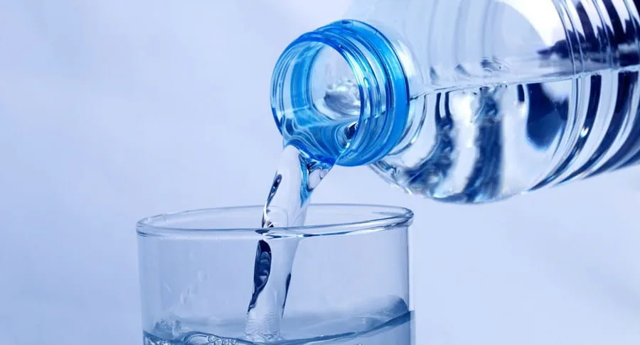 Water being poured from a plastic bottle into a glass