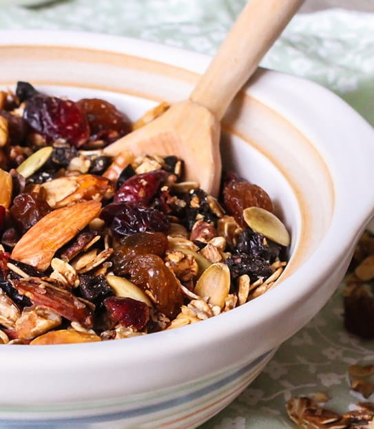 A bowl of granola with fruit and nuts