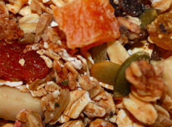 Plan rapproché d’un bol de céréales granola avec fruits et noix.
