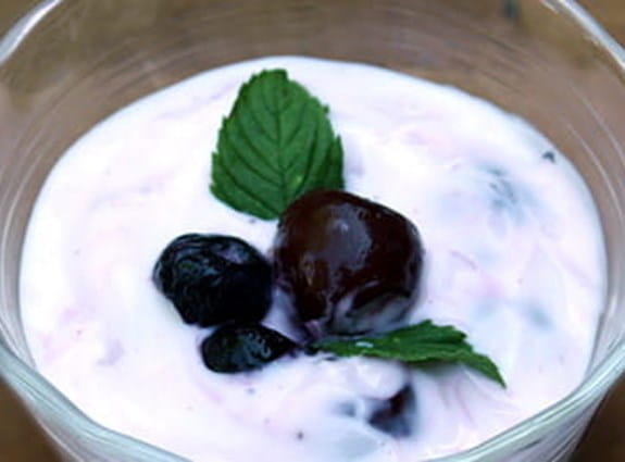 A bowl of greek yogurt with berries placed on top